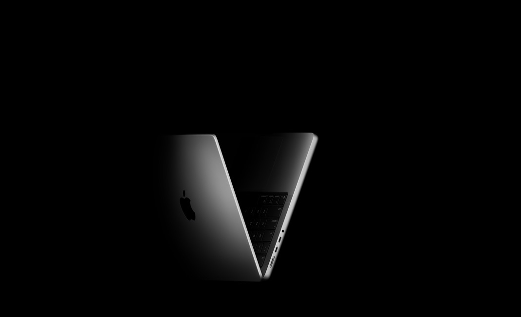 14-inch MacBook Pro, display partly open, positioned in the shape of a V, silver color, with left side ports: headphone jack, two Thunderbolt ports, and MagSafe connector